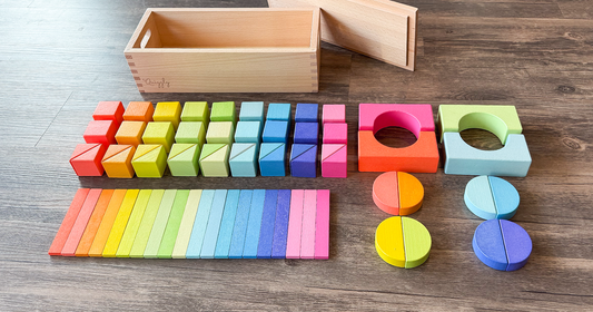 Organized layout of Quiggly’s 68-piece rainbow wooden block set on the floor, showcasing its bright colors and varied shapes