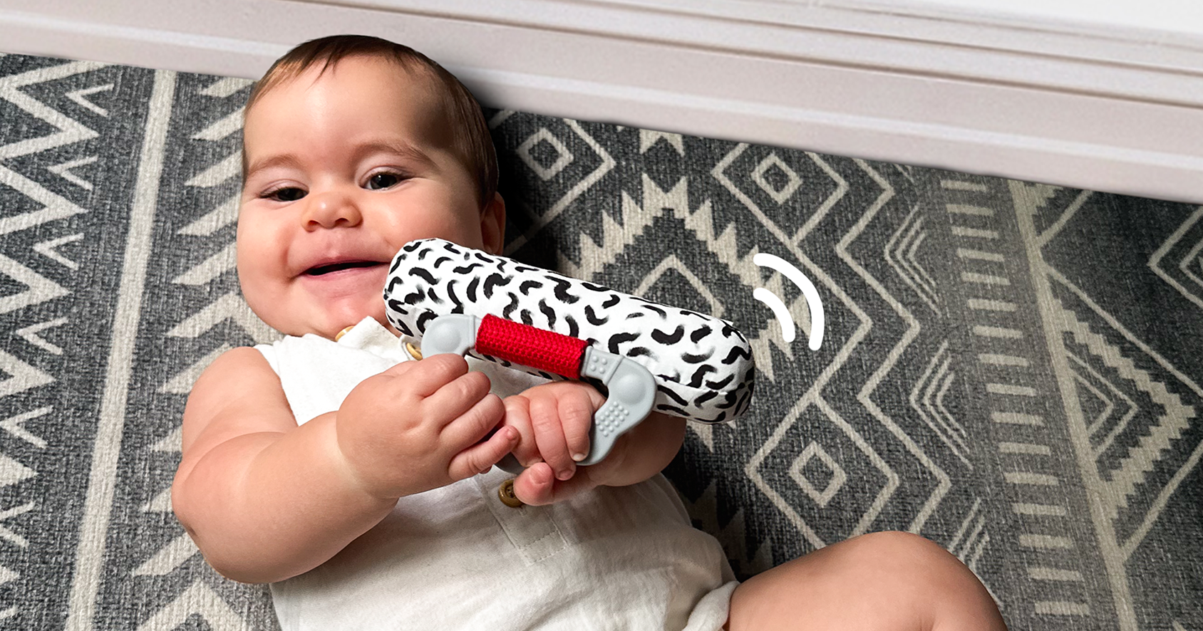 Baby shaking the high contrast rattle for sensory play