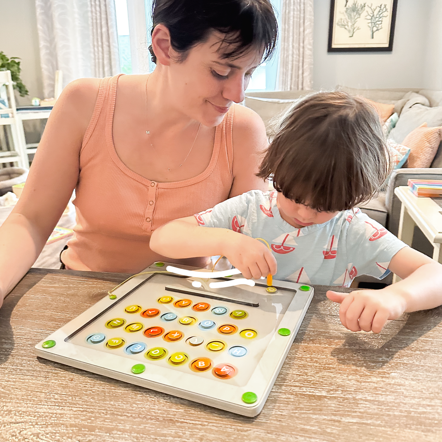 Mom interacting with child while playing with magnetic alphabet maze board