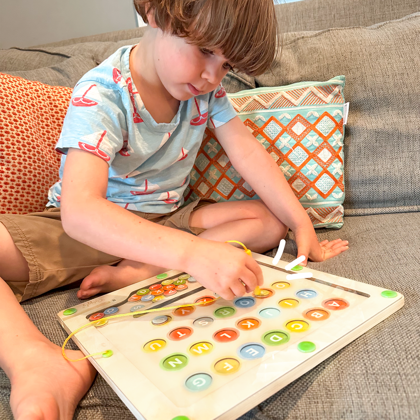 Child independently sorting letters on magnetic color and alphabet maze toy
