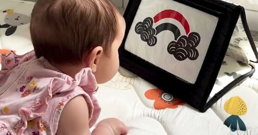 Baby focused on a high contrast flashcard with a black, white, and red design