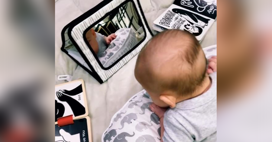 Baby enjoying tummy time with a high contrast newborn toy set