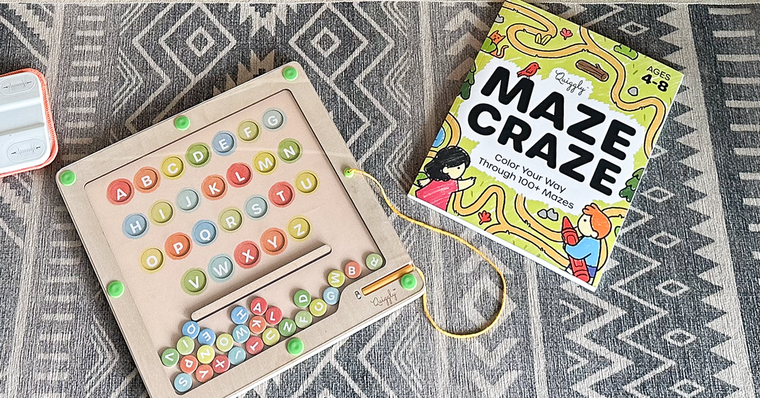 Quiggly’s educational maze-themed toys - including the Magnetic Alphabet & Color Maze, and Maze Craze book - spread out across the carpet