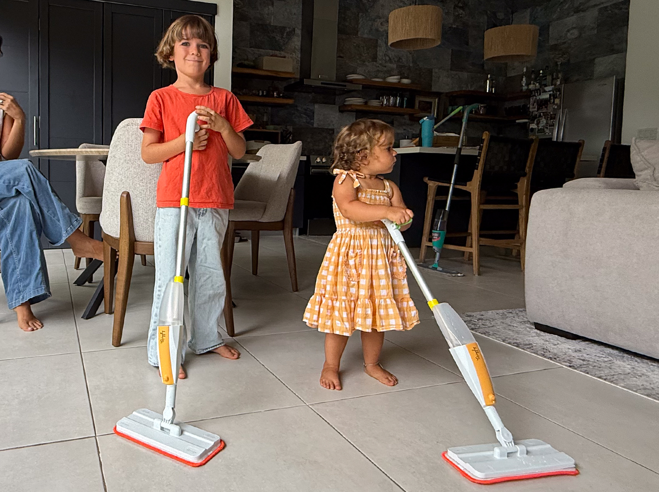 3 year old and 7 year old children using Quiggly toddler and big kids real spray mops at home