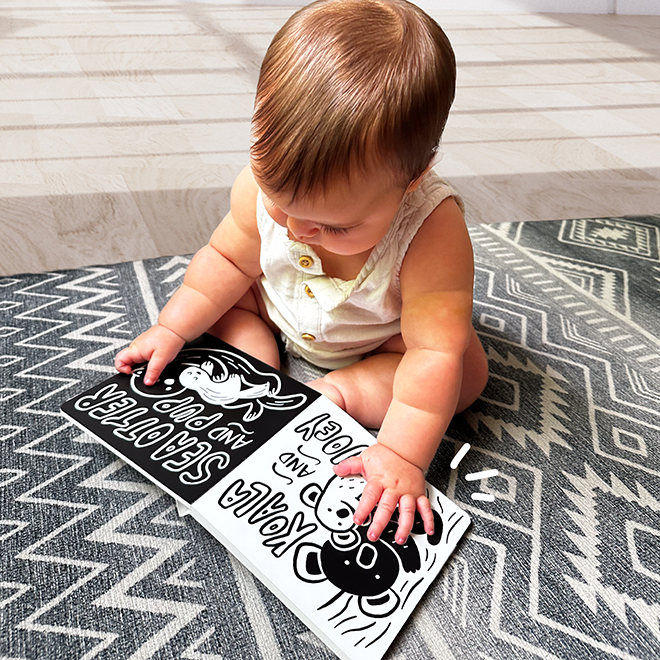 Baby flipping through the moms and babies high contrast board book
