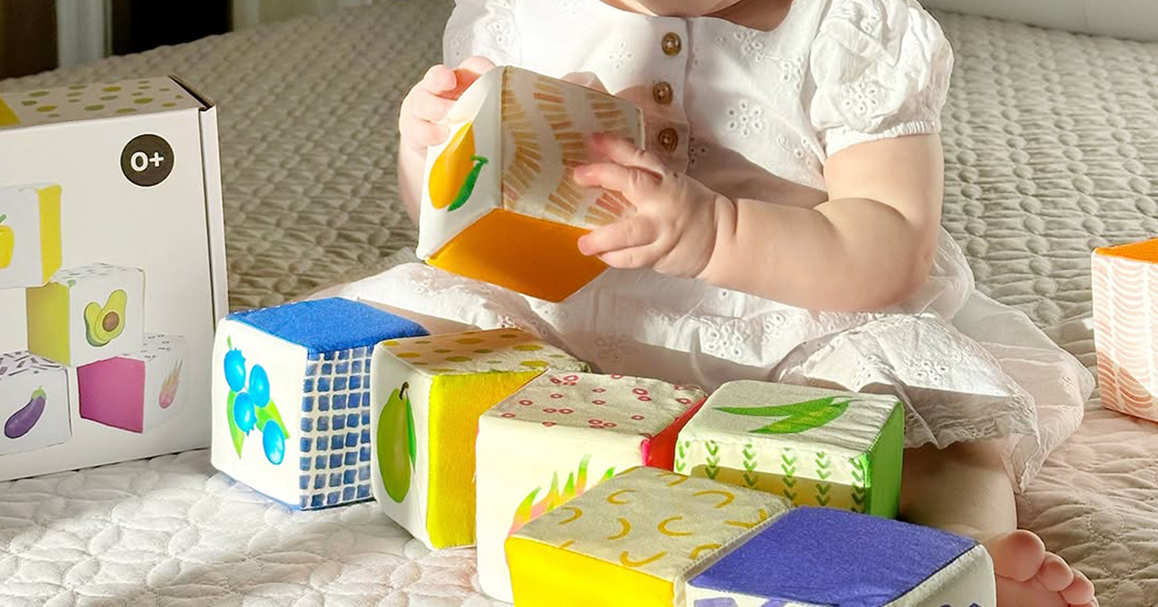 Toddler exploring crinkle blocks with colorful patterns