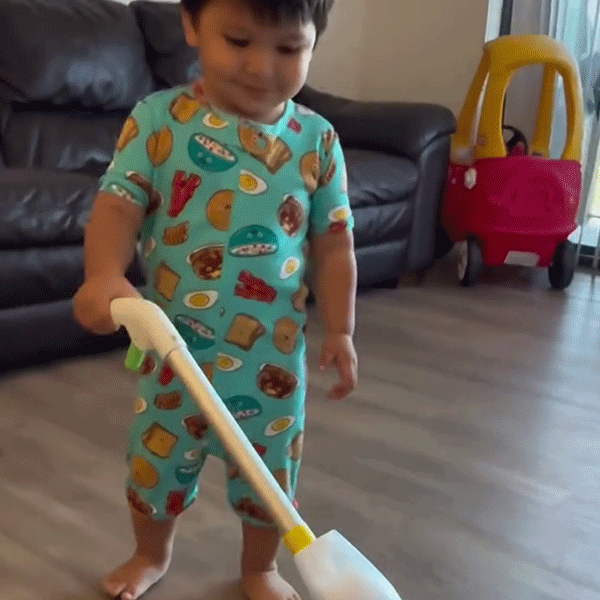 Young boy proudly mopping the floor with Quiggly real kids spray mop