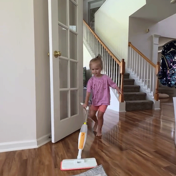 Child feeling accomplished after mopping with Quiggly kids spray mop