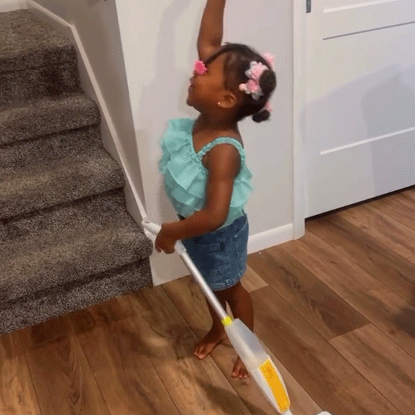 Little girl determined to clean the whole house with Quiggly real kids spray mop