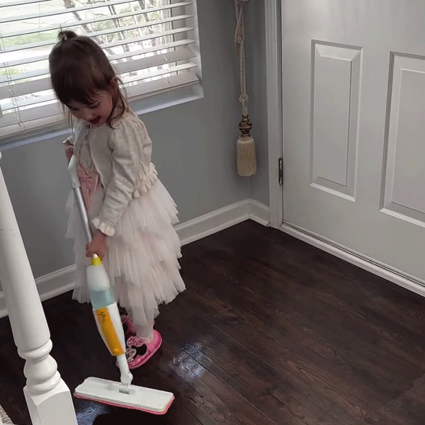Little girl excited to help clean the floor with Quiggly real spray mop