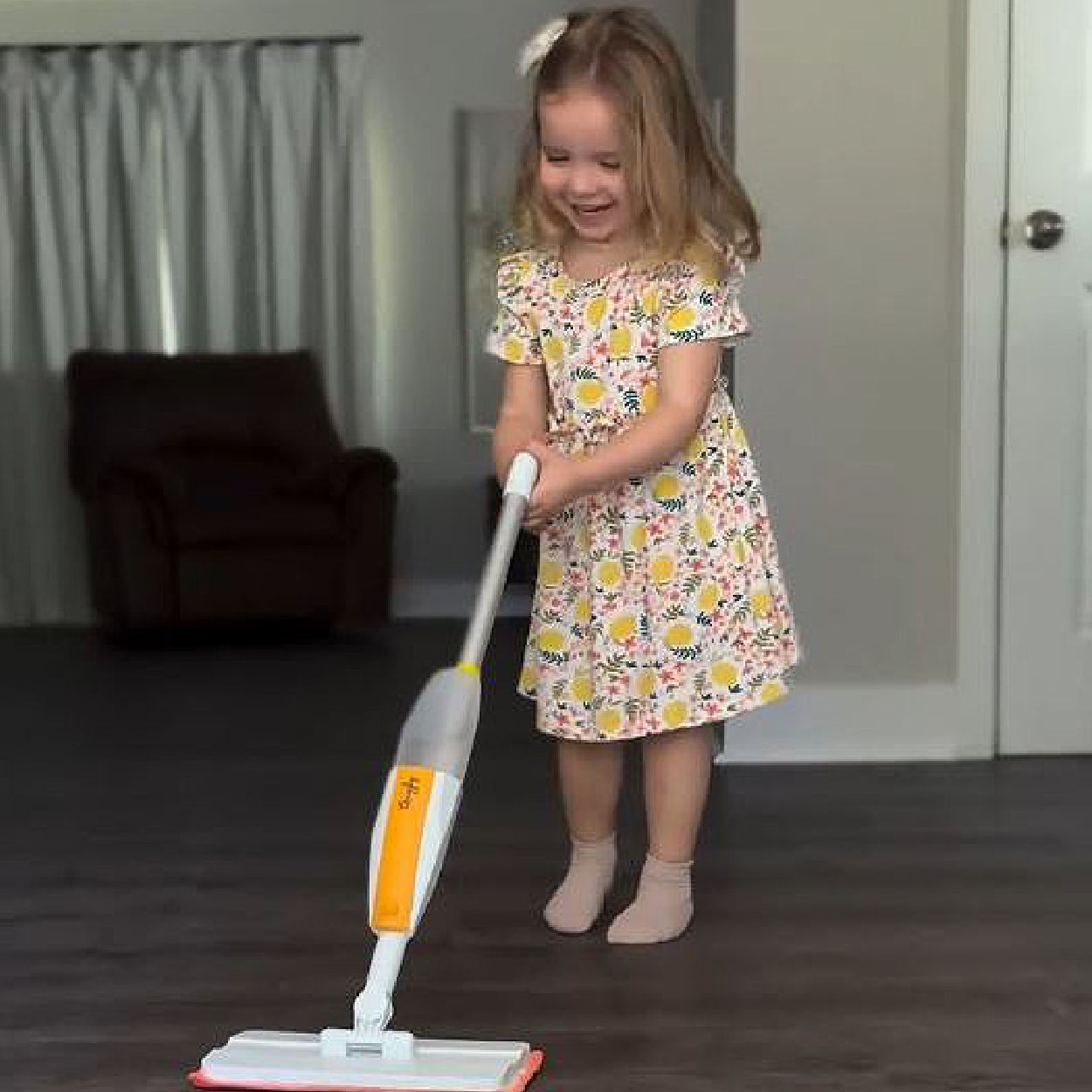 Little girl excited to help clean the floor with Quiggly real spray mop