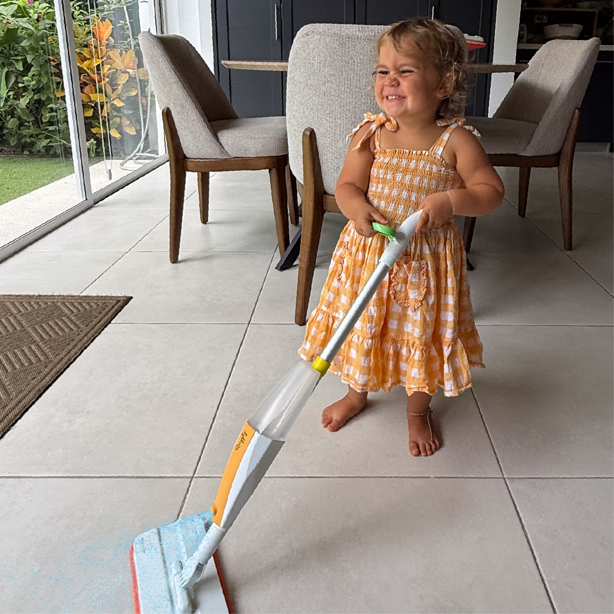 Little toddler excited to help clean the floor with Quiggly real spray mop
